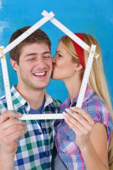 happy young couple paint in green and blue color white wall of their new home