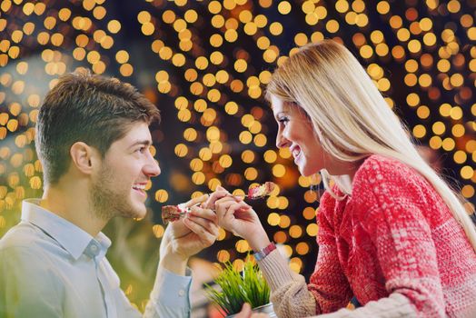 romantic evening date in restaurant  happy young couple with wine glass tea and cake