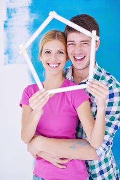 happy young couple paint in green and blue color white wall of their new home