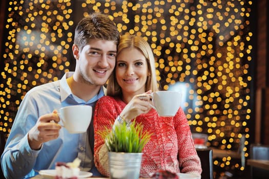 romantic evening date in restaurant  happy young couple with wine glass tea and cake