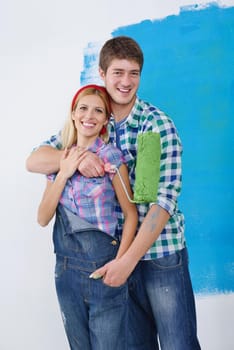 happy young couple paint in green and blue color white wall of their new home