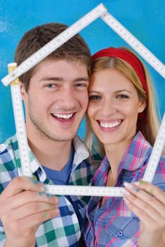 happy young couple paint in green and blue color white wall of their new home