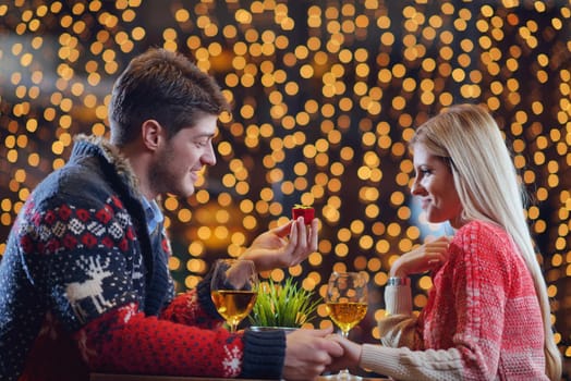 The young man gives a wedding ring   gift to  girl in restaurant