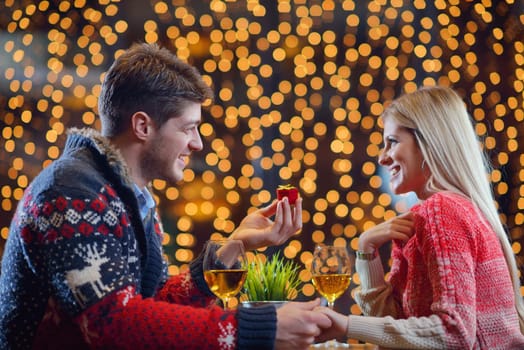 The young man gives a wedding ring   gift to  girl in restaurant