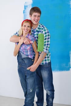 happy young couple paint in green and blue color white wall of their new home