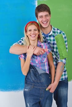 happy young couple paint in green and blue color white wall of their new home