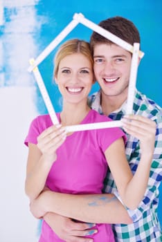 happy young couple paint in green and blue color white wall of their new home