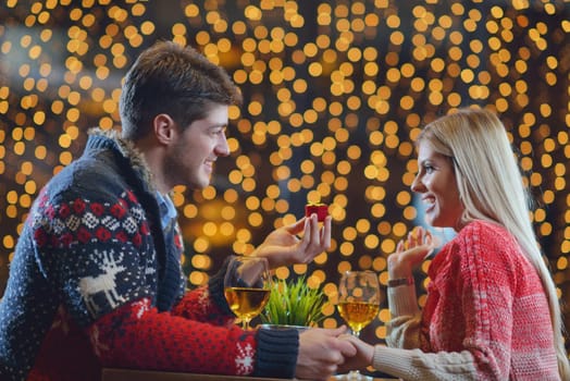 The young man gives a wedding ring   gift to  girl in restaurant