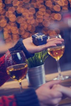 The young man gives a wedding ring   gift to  girl in restaurant