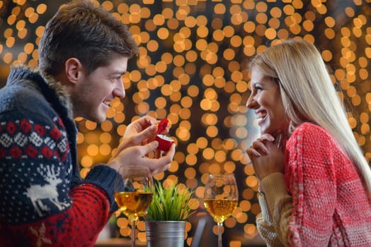 The young man gives a wedding ring   gift to  girl in restaurant