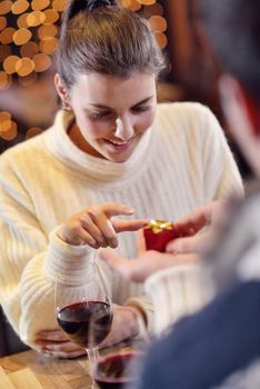 The young man gives a wedding ring   gift to  girl in restaurant