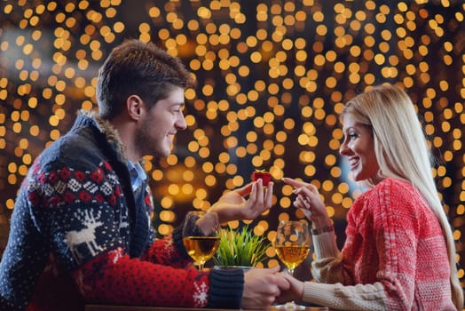 The young man gives a wedding ring   gift to  girl in restaurant