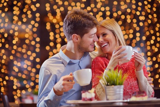 romantic evening date in restaurant  happy young couple with wine glass tea and cake