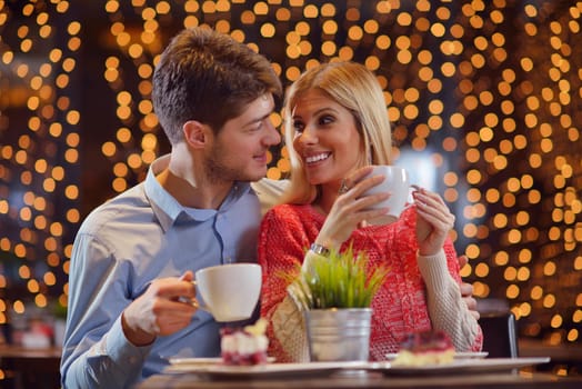 romantic evening date in restaurant  happy young couple with wine glass tea and cake