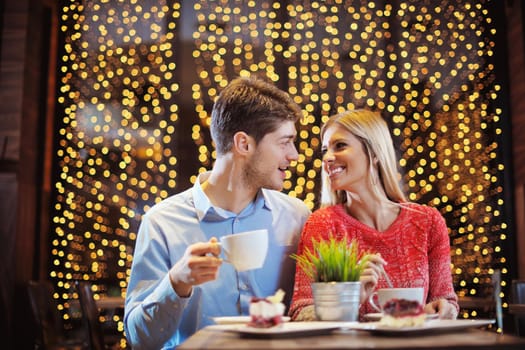 romantic evening date in restaurant  happy young couple with wine glass tea and cake