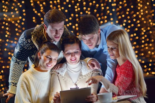 Group of happy people looking at a tablet computer