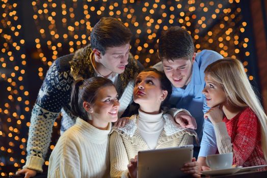 Group of happy people looking at a tablet computer