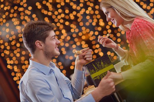 romantic evening date in restaurant  happy young couple with wine glass tea and cake