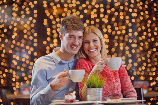 romantic evening date in restaurant  happy young couple with wine glass tea and cake