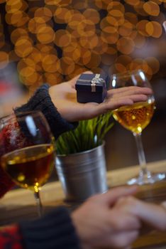 The young man gives a wedding ring   gift to  girl in restaurant