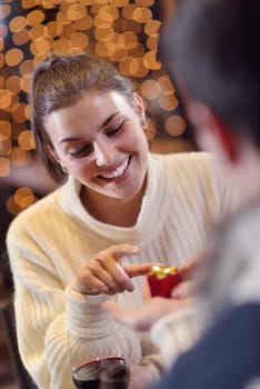 The young man gives a wedding ring   gift to  girl in restaurant