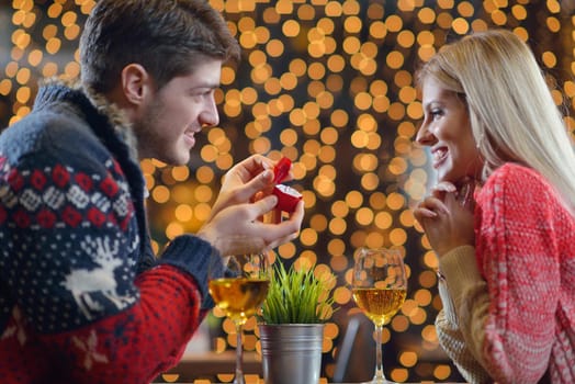 The young man gives a wedding ring   gift to  girl in restaurant