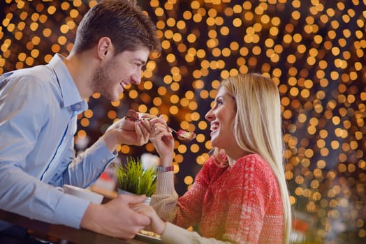 romantic evening date in restaurant  happy young couple with wine glass tea and cake