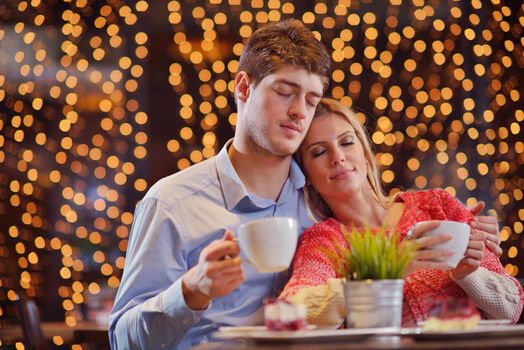 romantic evening date in restaurant  happy young couple with wine glass tea and cake