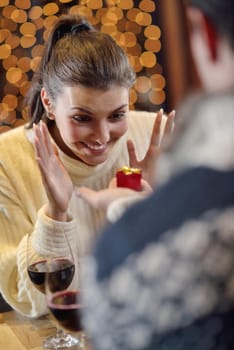 The young man gives a wedding ring   gift to  girl in restaurant