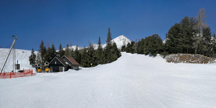 Empty red piste on Strbske pleso, Solisko ski resort, shot on Easter skiing, sunny spring day with no clouds in deep blue sky. Vysoke Tatry, Slovakia