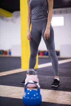 young  woman athlete exercise with fitness kettlebell at cross fitness gym