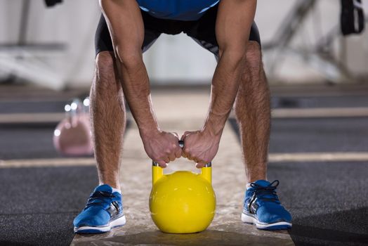 young  man athlete exercise with fitness kettlebell at cross fitness gym