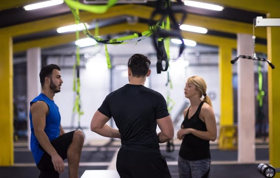 group of young healthy athletic people training jumping on fit box at cross fitness gym