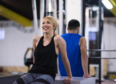 young couple athletes working out their arms using boxes at cross fitness gym