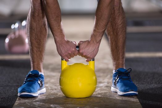 young  man athlete exercise with fitness kettlebell at cross fitness gym