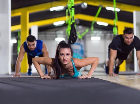 group of young healthy people doing pushups at crossfitness  gym