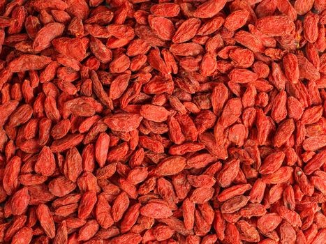 Detail high resolution closeup photo of goji berry (wolfberry - Lycium chinense) dried fruits heap shot from above.