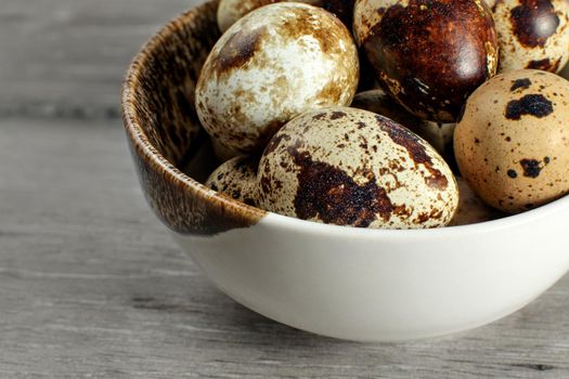 Detail on quail eggs in small bowl.