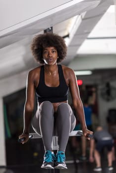 african american athlete woman workout out arms on dips horizontal parallel bars Exercise training triceps and biceps doing push ups