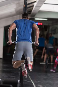 young muscular bodybuilder working out in gym doing exercises parallel bars  Concept sport