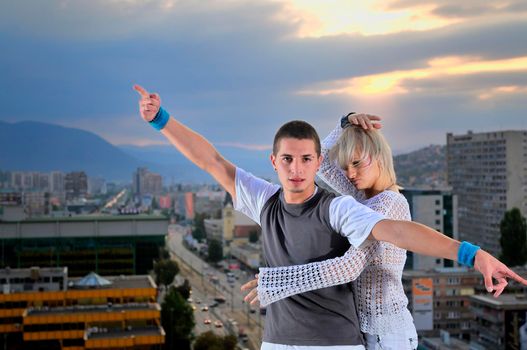 romantic urban couple dancing on top of the bulding