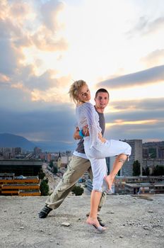 romantic urban couple dancing on top of the bulding