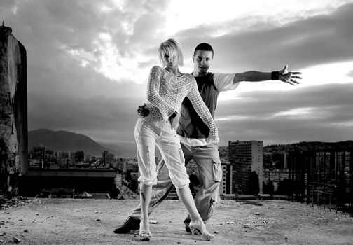 romantic urban couple dancing on top of the bulding