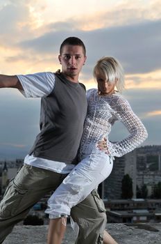 romantic urban couple dancing on top of the bulding 
