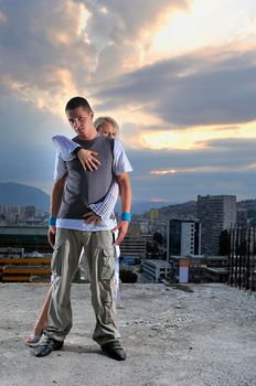 romantic urban couple dancing on top of the bulding