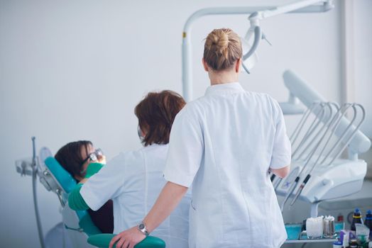 Closeup of a woman patient at the dentist waiting to be checked up with the woman doctor in the background