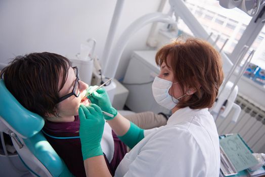 Closeup of a woman patient at the dentist waiting to be checked up with the woman doctor in the background