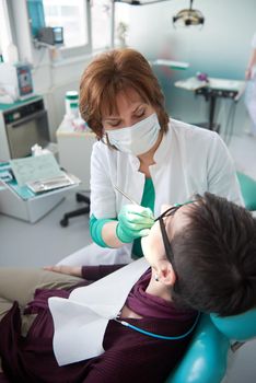 Closeup of a woman patient at the dentist waiting to be checked up with the woman doctor in the background