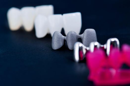 different types of dental tooth crowns isolated on blue background