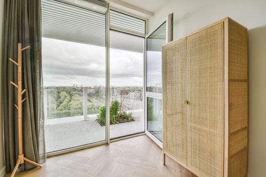A room with an open door to the balcony and with a curtain